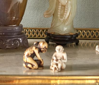 null Deux netsukes en ivoire sculpté, l'un représentant un personnage agenouillé...