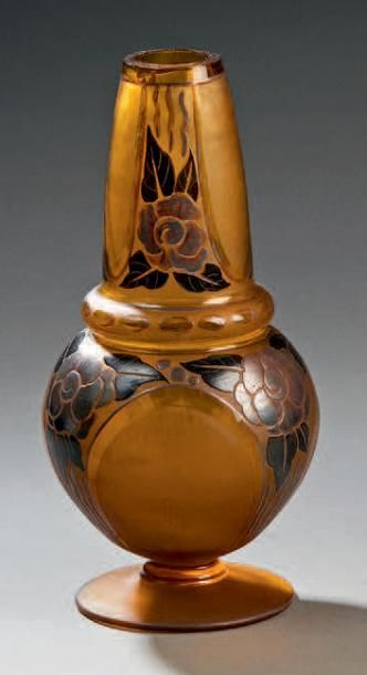 D'ARGYL Vase piriforme à long col en verre ambré reposant sur une base circulaire....
