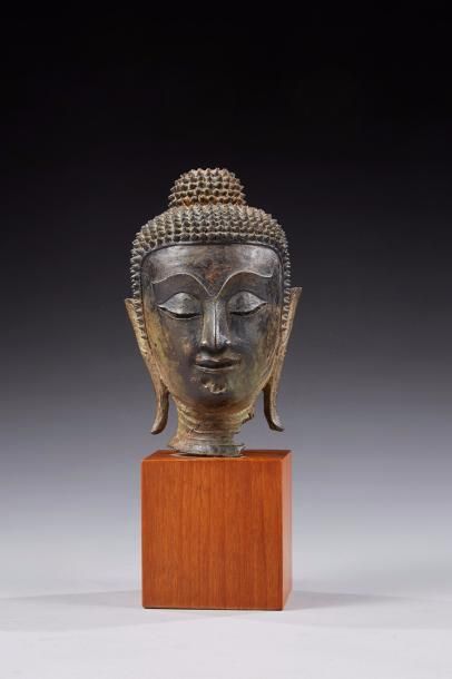 null Tête de Bouddha en bronze patiné, le visage méditatif, les yeux mi-clos, nez...