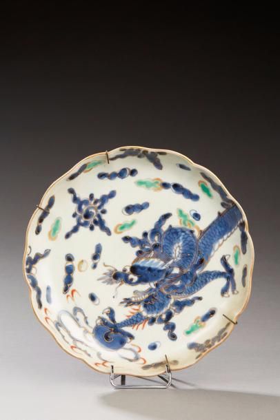 null Assiette creuse en porcelaine à décor en bleu d'un dragon poursuivant une perle...