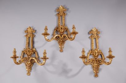 null Suite de trois appliques à deux bras de lumières en bronze moulé et doré, montant...