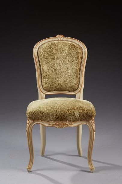 null Une chaise de style Louis XV en bois laqué et doré sculpté de fleurettes et...