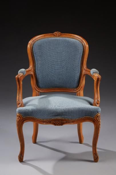 null Un fauteuil cabriolet de style Louis XV en bois naturel sculpté de fleurettes.

Garniture...