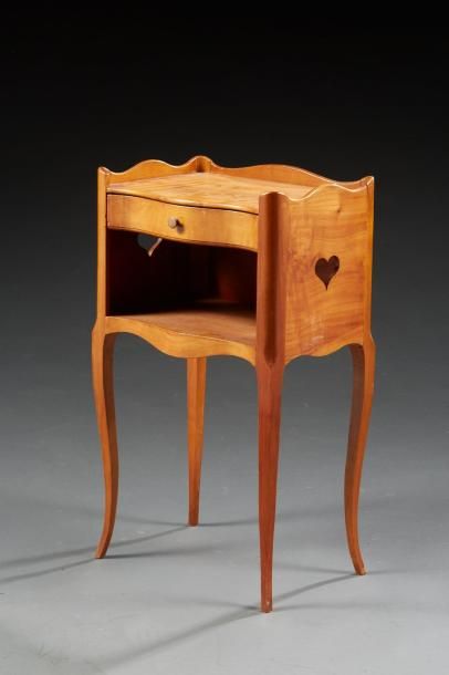 null Une table de chevet en bois naturel de style Louis XV, ouvrant par un tiroir...