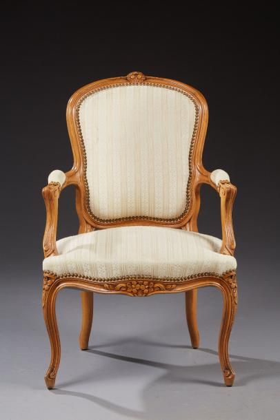 null Un fauteuil cabriolet de style Louis XV en bois naturel mouluré et sculpté de...