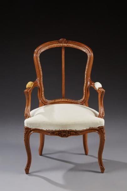 null Un fauteuil cabriolet de style Louis XV en bois naturel sculpté de fleurettes,...