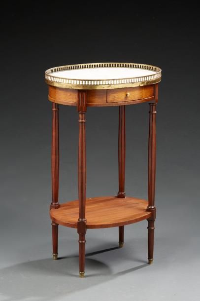null Une table de salon de forme ronde de style Louis XVI en bois teinté acajou,...