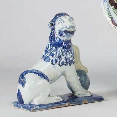 null Rouen 

Lion assis en faïence à décor en camaïeu bleu, la patte gauche posée...