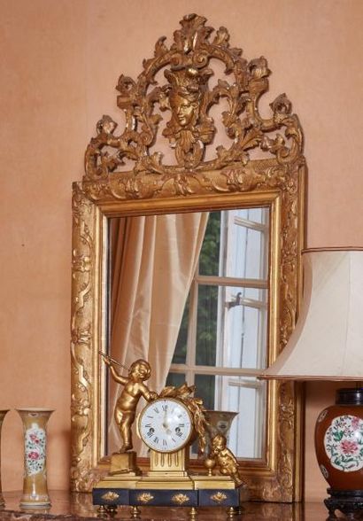 null Miroir de style Régence en bois sculpté et suc doré à décor de rinceaux, fronton...