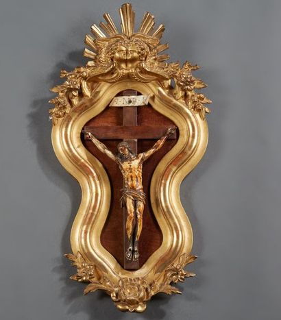 null Christ en ivoire patiné dans un cadre de forme violonée en stuc doré surmonté...