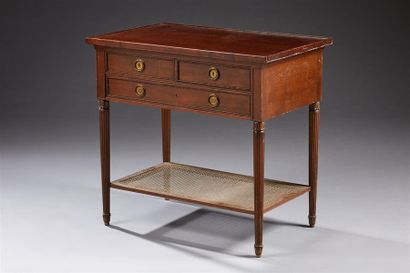 null Une table de style Louis XVI en acajou et bois teinté acajou, ouvrant par trois...