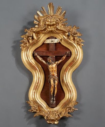 null Christ en ivoire patiné dans un cadre de forme violonée en stuc doré surmonté...