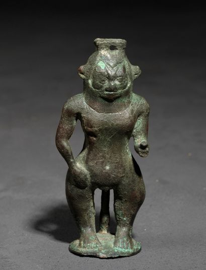 Statuette of god Bes standing. 
A receptacle...