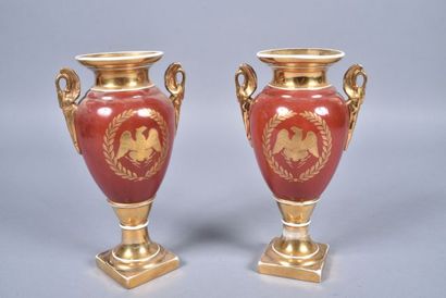 null PARIS. Paire de vases en porcelaine à fond rouge brique et doré en forme d'amphore...