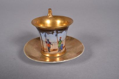 null PARIS. Tasse de forme jasmin et sa sous-tasse en porcelaine à fond doré et décor...