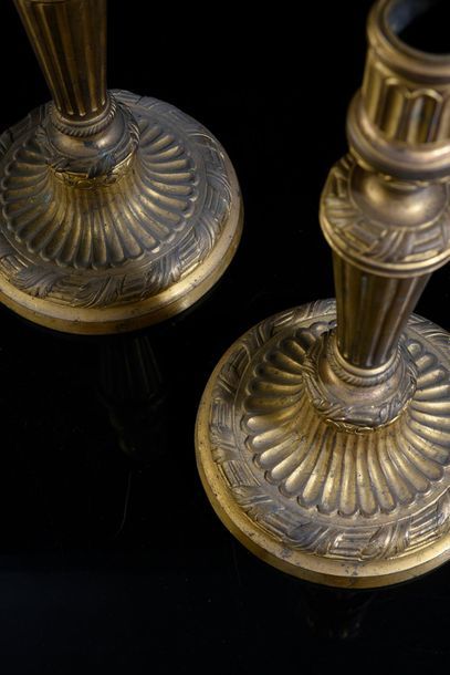 null Pair of candlesticks in chased and gilded bronze, decorated with flutes and...