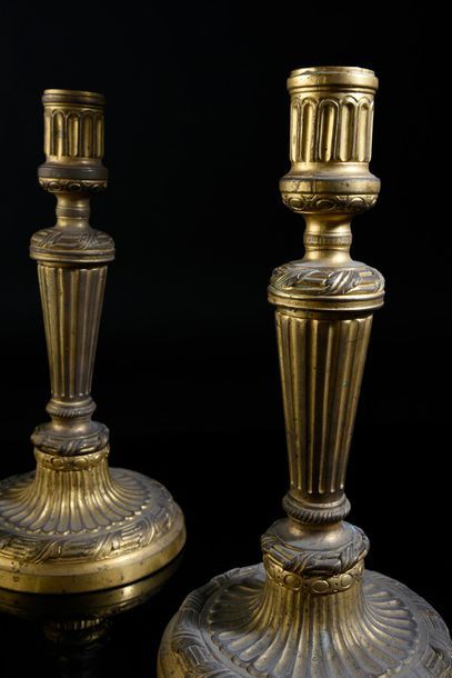 null Pair of candlesticks in chased and gilded bronze, decorated with flutes and...
