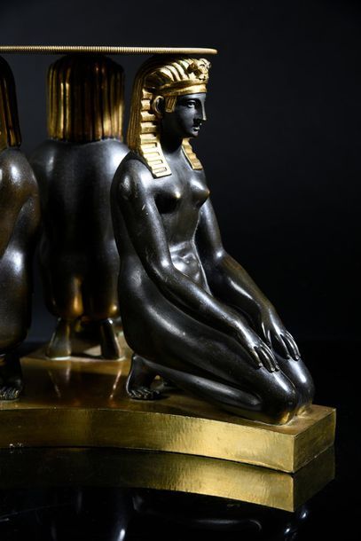 null Chiseled, patinated and gilded bronze base showing three naked Egyptian women...
