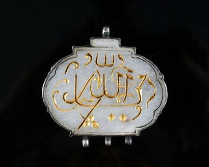 null White nephrite pendant inscribed with gilded suras, silver mount.
Ht 5 cm, larg....