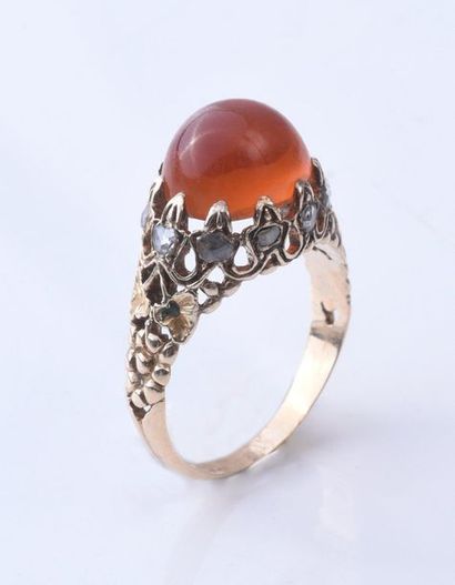 null Ring in 585e gold, adorned with a carnelian cabochon, the body of the ring openworked...