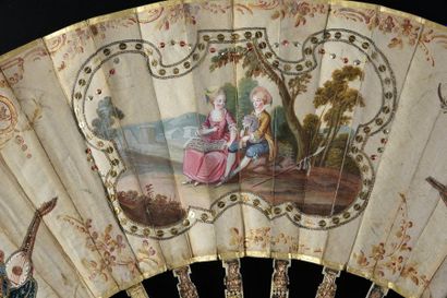 null Couple de musiciens, vers 1770-1780
Eventail plié, feuille en soie crème peinte...