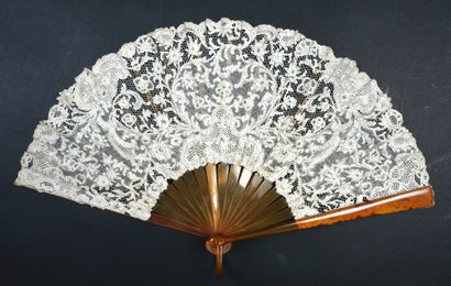 null Delicate volutes, circa 1900
Folded fan, the leaf in bobbin lace decorated with...