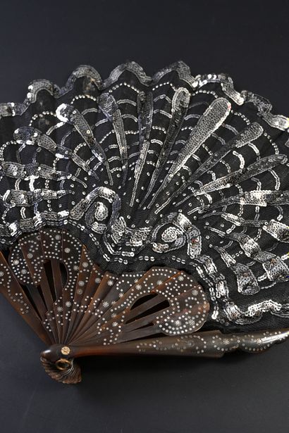 null Silver shell, circa 1900
Small folded fan, the black tulle leaf embroidered...