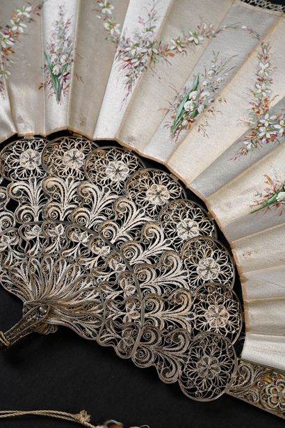 null Silver filigree, circa 1880
Folded fan, the cream silk leaf painted with five...