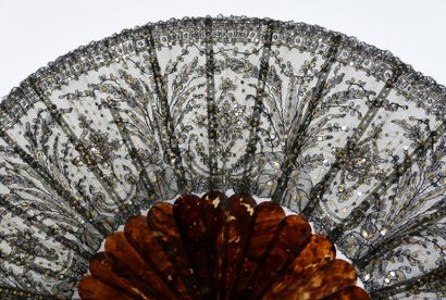 null Sequins and lace, circa 1880
Folded fan, the leaf in black lace, with repeated...