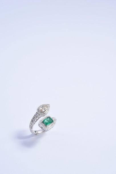 null Crossed ring in 750° white gold, set with a rectangular emerald and a pale yellow...