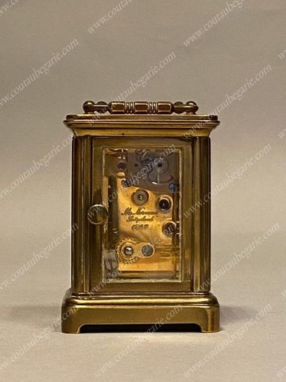 null TRAVEL OFFICER'S CLOCK. 
 In gilded metal, white enamel dial, Roman numerals....