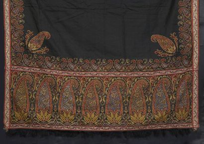 null Long cashmere shawl, circa 1840, plain black field framed with garlands of palmettes...