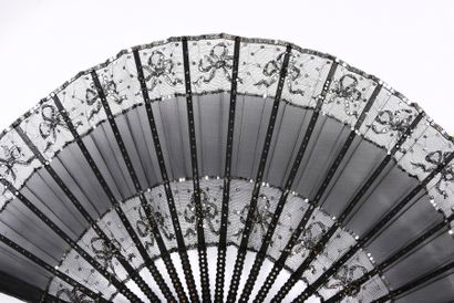 null Silver knots, circa 1890
Large folded fan, the leaf made of black silk and tulle,...