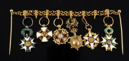 null BAR FOR MINIATURE DECORATIONS. Two gold chains hold the miniature orders of...