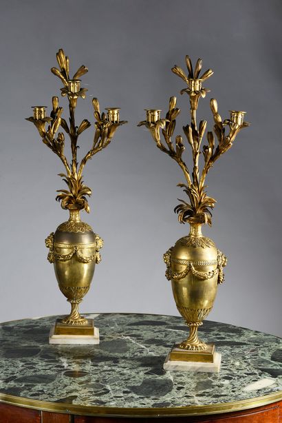 null Pair of chased and gilt bronze candelabra consisting of an ovoid vase decorated...