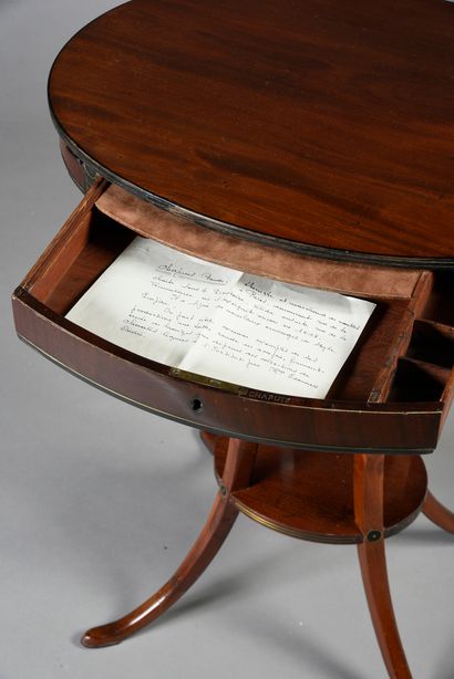 null Oval pedestal table in mahogany and mahogany veneer, it rests on four curved...