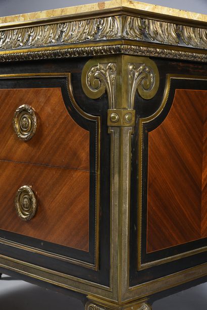 null A rosewood veneered chest of drawers in blackened wood frames, opening to two...