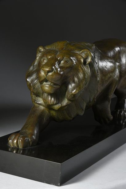 E. GUY. (Actif dans les années 1930/40) 
Lion walking.
Bronze with a light brown...