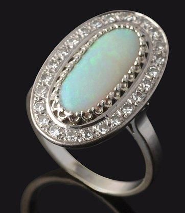 null Bague en or gris, ornée d'une opale de forme ovale dans un entourage de diamants....
