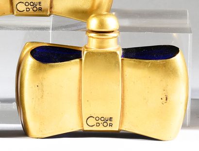 GUERLAIN - «Coque d'Or» - (1937) 
Moulded midnight blue tinted glass bottle featuring...
