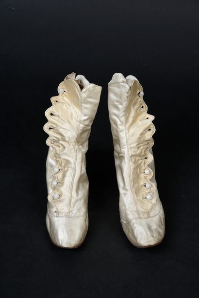 null . Pair of high boots, late 19th century, in cream satin with small covered heels,...