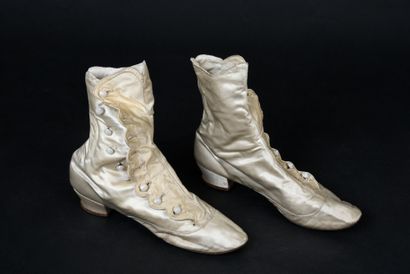 null . Pair of high boots, late 19th century, in cream satin with small covered heels,...