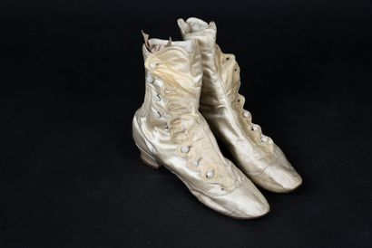 null . Pair of high boots, late 19th century, in cream satin with small covered heels,...