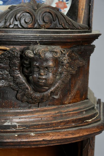 null A carved oak display case decorated with cherubs, flowers, sunflowers and twisted...
