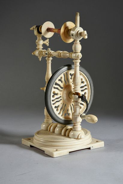 A turned ivory spinning wheel, it rests on...