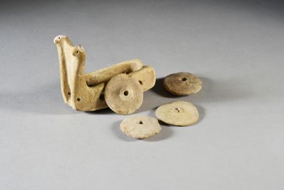 null Miniature cart with four wheels, decorated with two stylized zoomorphic figures....