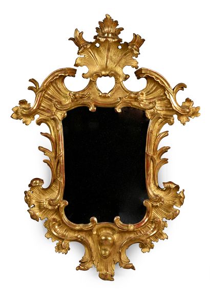 null Carved and gilded wooden mirror in the Baroque style.
The bevelled mirror.
H....