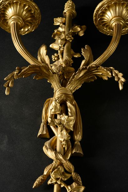 null A pair of two-light sconces in chased and gilt bronze.
After the model delivered...