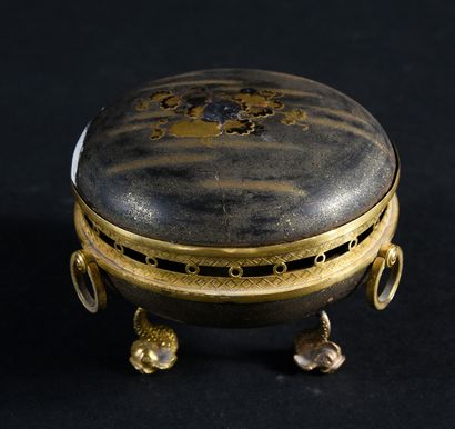 null A Japanese lacquer and chased and gilded bronze incense burner, resting on a...