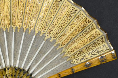 null Soleil d'or, vers 1800-1810
Éventail plié, la feuille en gaze brodée de paillettes...